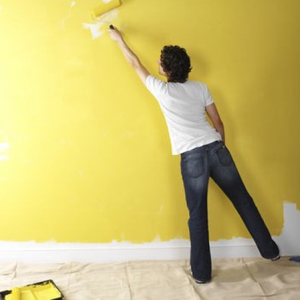 Man painting a wall yellow